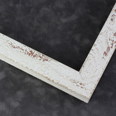 This textured frame features a distressed style and a desert-like finish. The face is a warm green tinged white with red-toned natural wood finish showing through the distressed surface.