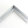 1 " deep stepped metal floater frame. This frame has a slim face and medium profile. It comes in silver and features a horizontal brushed texture. Dispersed light is reflected.